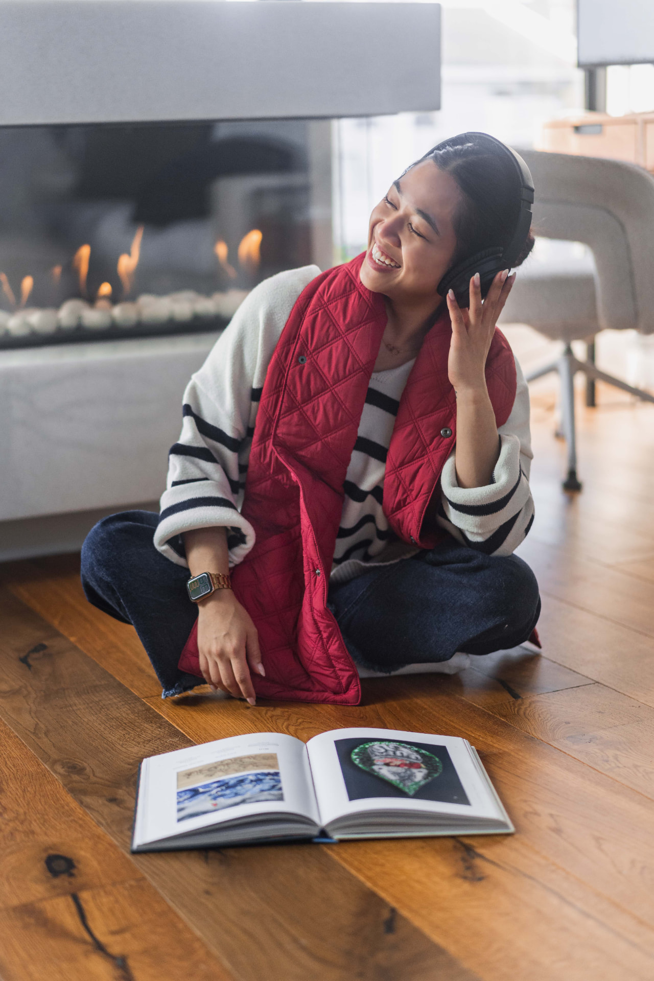 Woman relaxing by the fireplace wearing the red 418 Scarf